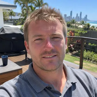 Portrait of Brodie Kerslake, a man in his thirties with short hair and a grey polo shirt