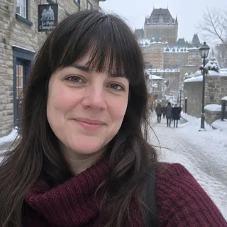 Portrait de Noémie Lacasse, femme dans la trentaine aux cheveux bruns et chandail bourgogne