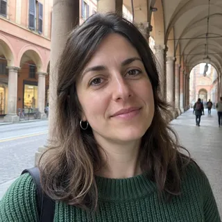 Ritratto di Serena Bortolin, donna sulla trentina con capelli castani e un maglione verde